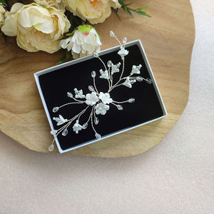 Bijou de cheveux de design original avec fleurs blanches en argile polymère et cristal transparent sur fil argenté pour coiffure de mariage romantique champêtre