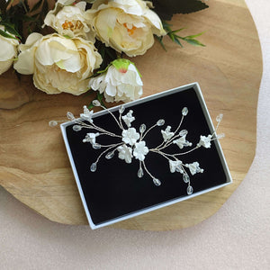 Bijou de cheveux de design original avec fleurs blanches en argile polymère et cristal transparent sur fil argenté pour coiffure de mariage romantique champêtre