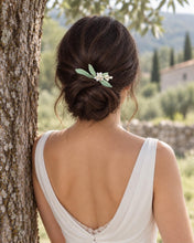 Charger l'image dans la galerie, Vue arrière d’une mariée portant le peigne à cheveux Olive au-dessus d’un chignon bas, avec feuilles vert pâle et fleurs blanches