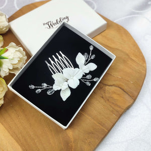 Bijou de cheveux sur peigne avec cristal transparent et fleurs et feuilles blanches en porcelaine froide pour chignon ou coiffure de mariage