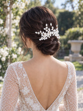 Charger l'image dans la galerie, Large peigne à cheveux floral avec fleurs et feuilles en porcelaine blanche, porté sur chignon bas de mariée, vue arrière trois quarts