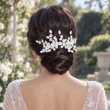 Charger l'image dans la galerie, Peigne de mariée floral en porcelaine froide, porté sur chignon bas avec fleurs et feuilles blanches