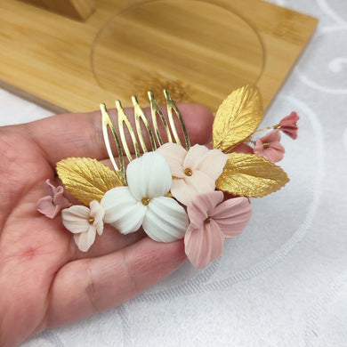 Peigne de mariage avec fleurs rose, blush et ivoire et feuilles dorées en porcelaine froide pour coiffure de mariage bohème ou champêtre.