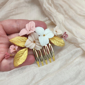 Peigne de mariage avec fleurs rose, blush et ivoire et feuilles dorées en porcelaine froide pour coiffure de mariage bohème ou champêtre.
