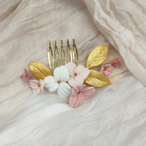 Peigne de mariage avec fleurs rose, blush et ivoire et feuilles dorées en porcelaine froide pour coiffure de mariage bohème ou champêtre.