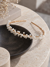 Charger l'image dans la galerie, Serre-tête de mariage doré avec perles nacrées posé sur un bol noir et une table en pierre claire