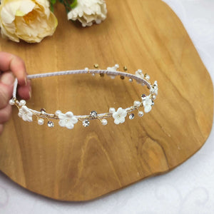 Serre-tête fin avec perles nacrées, cristaux de strass transparents et petites fleurs blanches en porcelaine froide pour coiffure de mariage ou communion