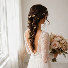 Charger l'image dans la galerie, Mariée en robe de dentelle tenant un bouquet de fleurs et portant une vigne de cheveux dorée dans une longue tresse