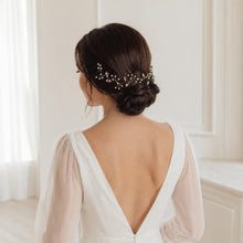 Charger l'image dans la galerie, Mariée vue de trois quarts avec chignon bas brun et liane de cheveux en perles