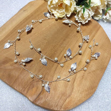 Charger l'image dans la galerie, Vigne de cheveux Sybile en finition argentée, composée de feuilles délicates et de perles, présentée à plat.