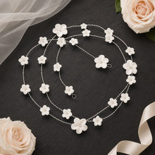 Charger l'image dans la galerie, Longue vigne de cheveux avec petites et grandes fleurs blanches, disposée en spirale sur une ardoise avec voile, rose et ruban de satin.