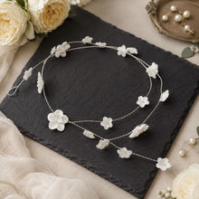 Charger l'image dans la galerie, Vigne de cheveux argentée avec fleurs blanches en porcelaine froide, présentée sur une ardoise sombre avec décor romantique.