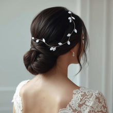 Charger l'image dans la galerie, Vigne de cheveux Flora en feuilles de porcelaine blanche portée sur chignon bas de mariée.