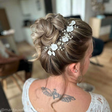 Charger l&#39;image dans la galerie, bijou de cheveux en guise de vigne de perles nacrées en verre, cristaux transparents et feuilles et fleurs blanches en porcelaine froide sur chignon haut de mariage