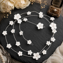 Charger l'image dans la galerie, Longue liane de cheveux avec fleurs en porcelaine blanche, présentée sur fond ardoise