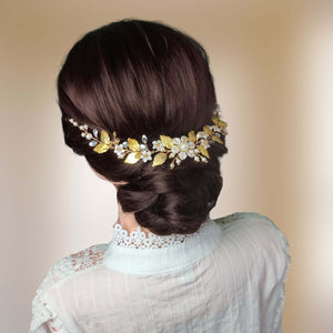 Vigne de cheveux florale semi-rustique avec feuilles dorées, perles, et strass posée à l'arrière-tête