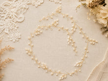 Charger l'image dans la galerie, Longue vigne de cheveux avec perles, cristaux et branches façon gypsophile sur fil doré, présentée à plat sur fond beige