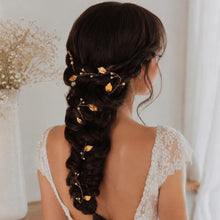 Charger l'image dans la galerie, Fine vigne de cheveux bohème romantique avec perles et feuilles dorées, portée par une mariée aux cheveux bruns sur longue tresse. Vue de près à 3/4 droite.