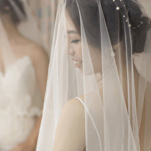 Charger l'image dans la galerie, Vigne de cheveux Chloé en perles portée par une mariée, accessoire discret sous le voile.