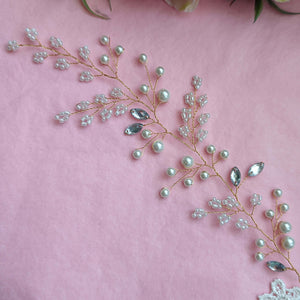 Gros plan de vigne de cheveux latérale en perles, perles de rocaille et strass sur fil doré pour mariage bohème ou champêtre
